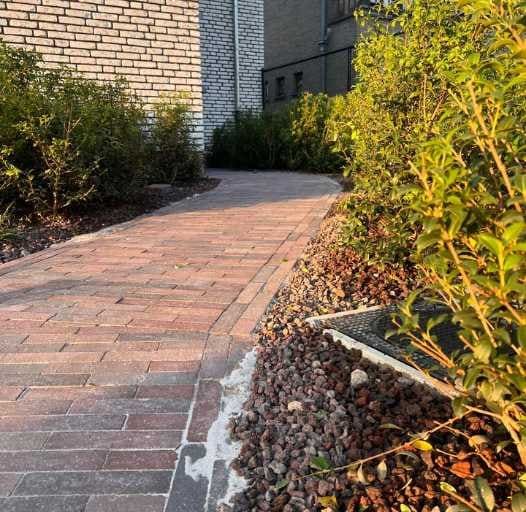 Aangelegd pad met plantvakken en grindafwerking